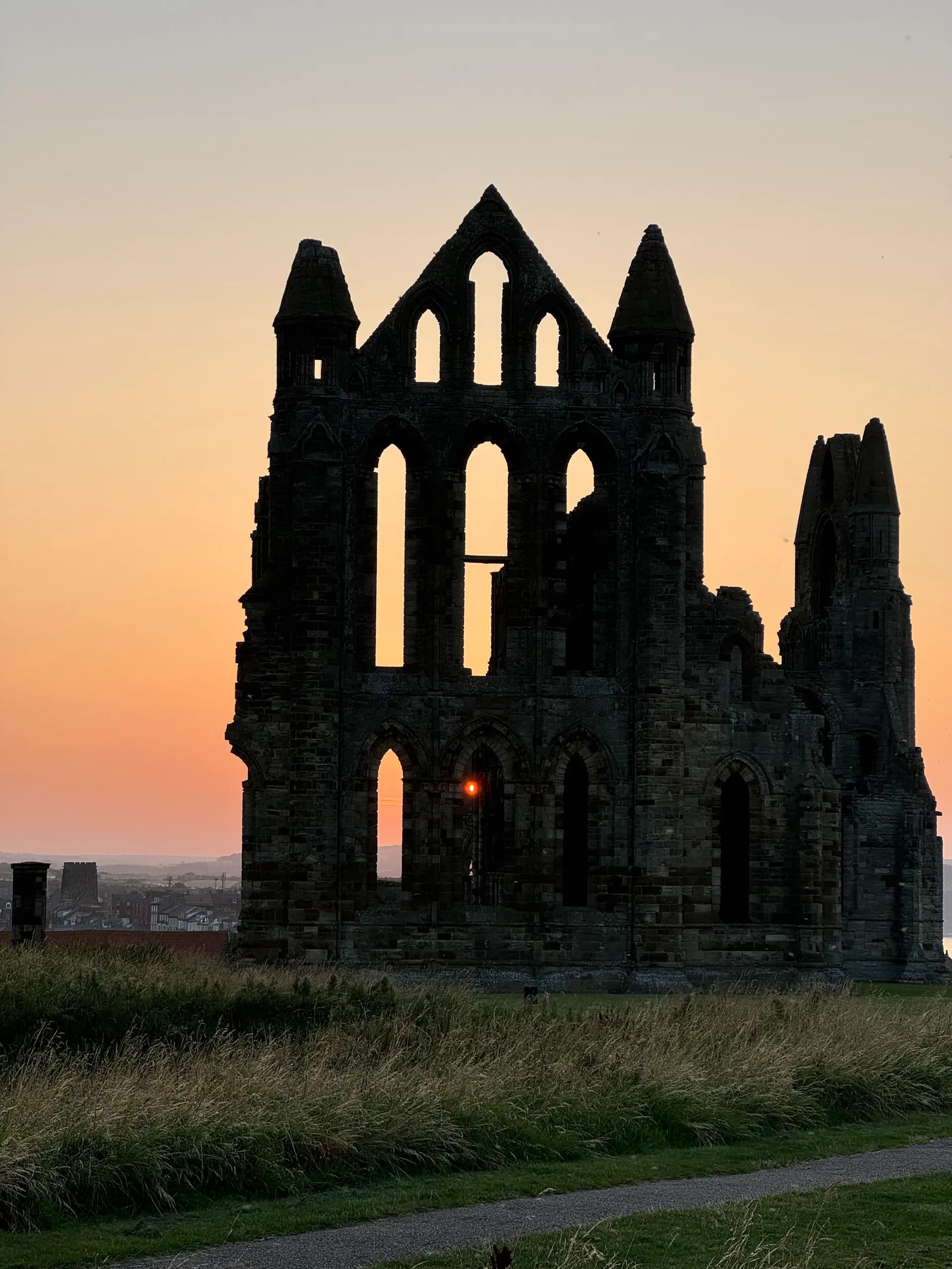 Whitby Abbey silhouetted against a sunset sky