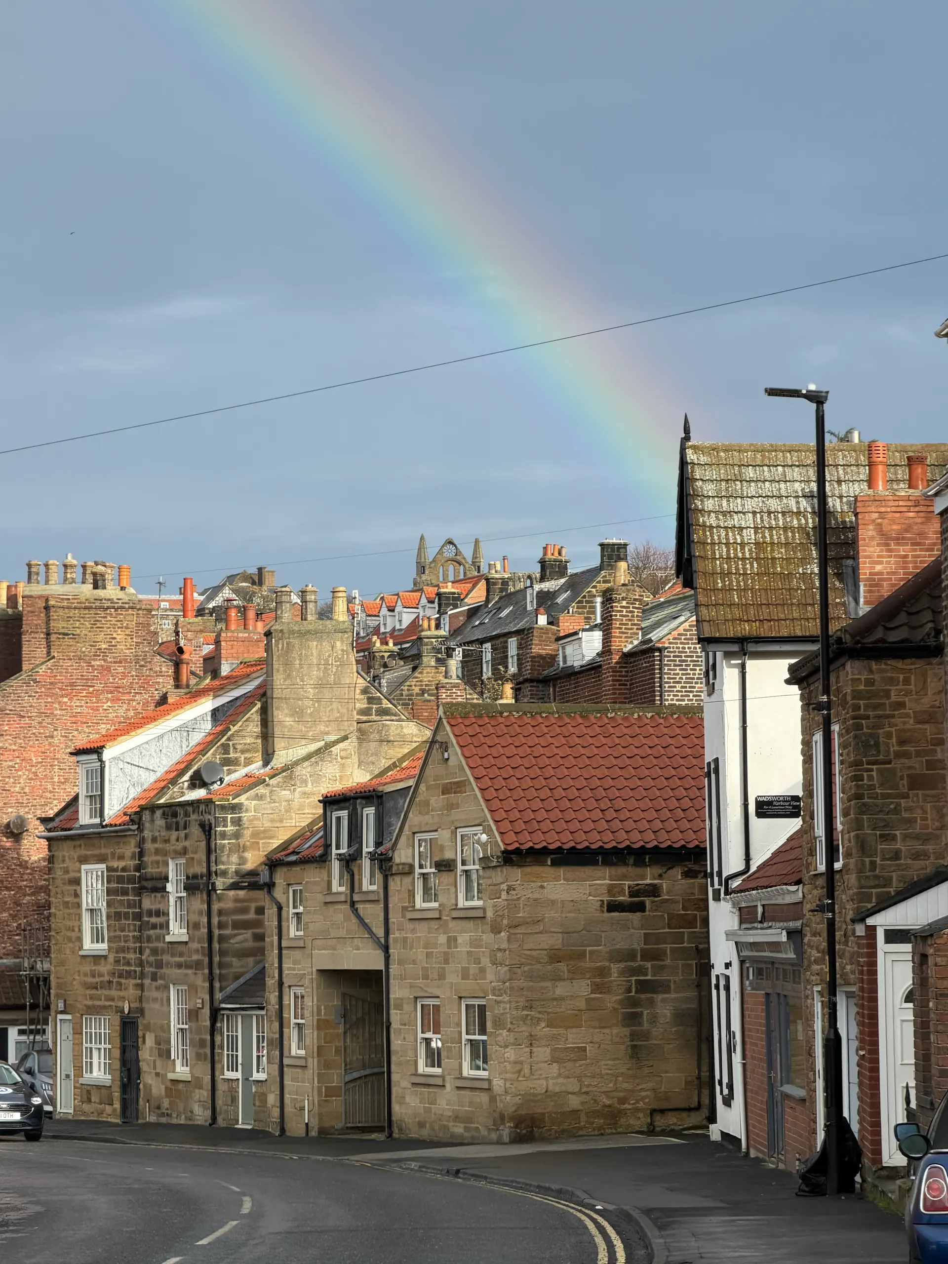 Rainbow over Whitby’s stone cottages and red tiled roofs