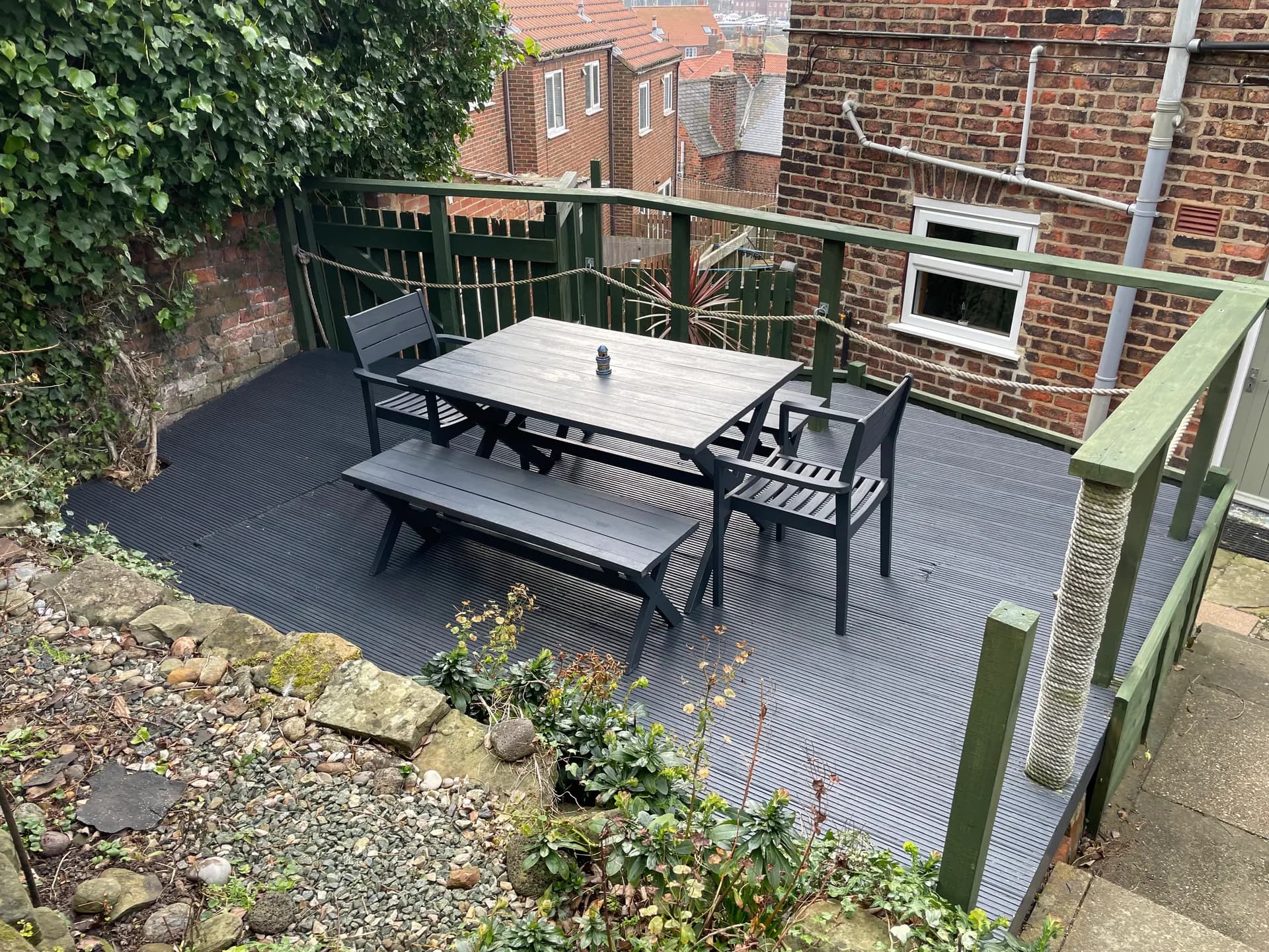 Decked rear terrace with outdoor table, bench and chairs
