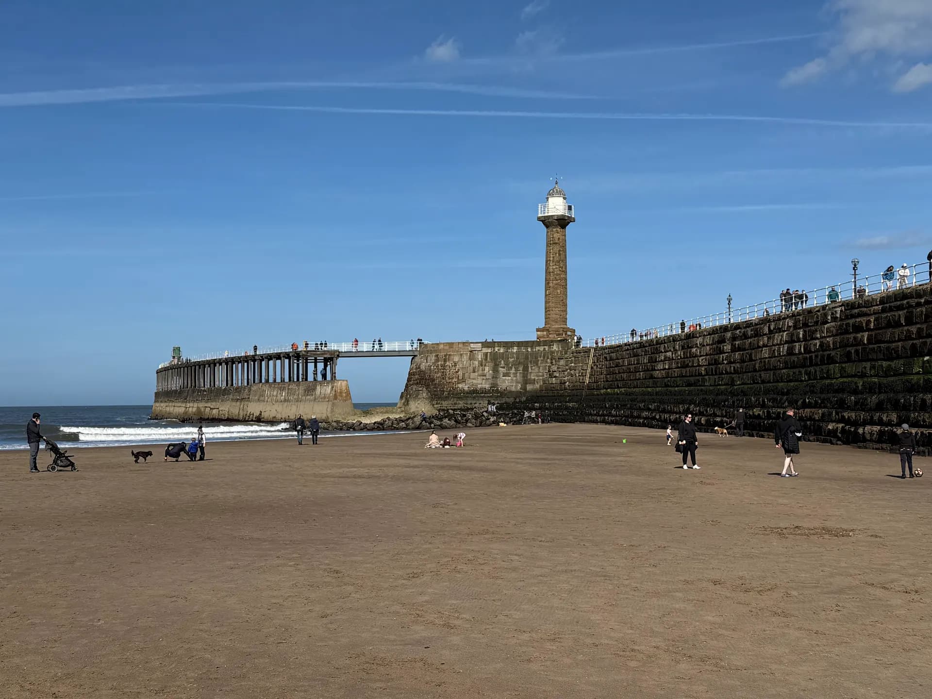 Whitby beach and the west pier lighthouse on a clear day